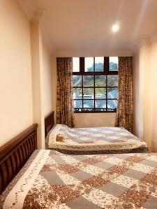 金马仑高原蔡氏杜松子酒酒店的卧室设有两张床,带窗户