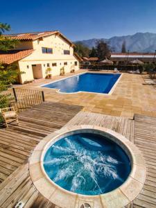 洛斯安第斯Howard Johnson Hotel Rinconada de Los Andes的房屋旁的木甲板上的热水浴池