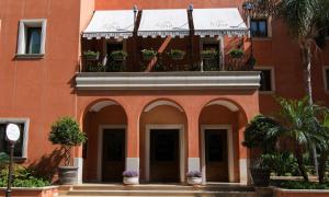 切法卢阿尔特密丝酒店的橙色的建筑,带有盆栽阳台