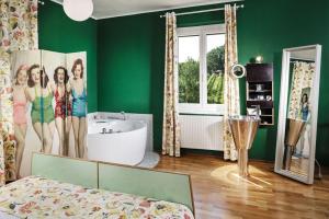 Sankt Nikolai im SausalWeingartenhotel Harkamp Südsteiermark的绿色客房设有浴缸、床和镜子