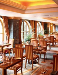 基拉尼基拉尼广场温泉酒店的餐厅设有木桌、椅子和窗户。