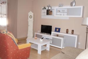 阿尔玛格鲁Apartamento Salvador 37的客厅配有电视、椅子和桌子