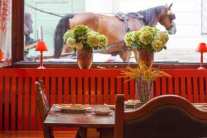 萨尔茨堡沃尔夫酒店的一张桌子,上面有两瓶花花和一匹马,背面是