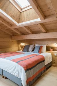 Arâches-la-FrasseCoco Chalet的卧室设有一张木制天花板上的大床