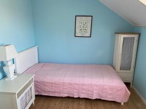 滨海贝亨Pacific, spectacular seaview的一间卧室设有粉红色的床和蓝色的墙壁。
