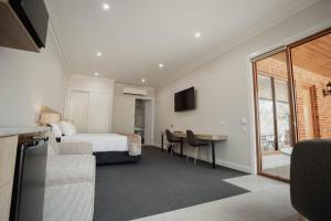 本迪戈Red Waratah Accommodation的配有一张床和一张书桌的酒店客房
