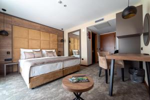 斯诺基米里亚娜及拉斯托克酒店的酒店客房设有一张大床和一张桌子。