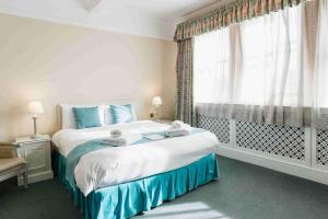 牛津St Margaret's Hotel的一间卧室设有一张大床和一个窗户。