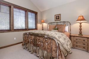 马姆莫斯湖Woodwinds 22的一间卧室配有一张床、梳妆台和窗户。
