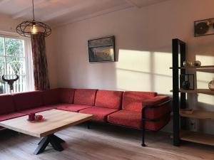卑尔根De Specht的客厅配有红色的沙发和桌子