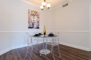 洛杉矶Beverly Hills Adjacent 2-Bedroom Penthouse的一张带两把椅子的玻璃桌和一瓶葡萄酒