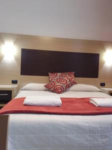 维亚雷焦普拉亚酒店的一张配有红色和白色枕头的大床