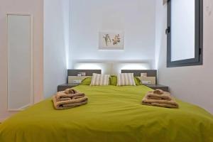 马拉加Apartamento Centro Histórico I的一间卧室配有绿床和2条毛巾