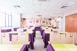 河源麗枫酒店·河源万隆城店的配有桌椅、紫色和绿色桌子的房间