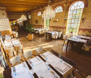 罗登Cuisinerie Mensinge With Dreams的一间带桌椅和吊灯的餐厅