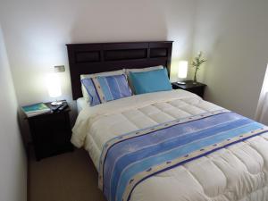 维纳德马迪帕特门托阿夸玛尔公寓的一间卧室配有一张带2个床头柜的大床