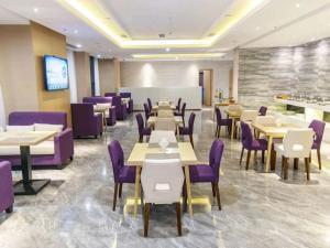 巴中麗枫酒店·巴中财富中心店的一间带桌子和紫色椅子的用餐室
