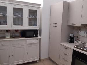 法萨诺appartamento butterfly的白色的厨房配有白色的橱柜和微波炉