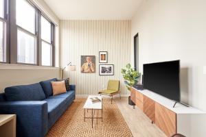 底特律Sonder The Randolph的客厅配有蓝色的沙发和平面电视。