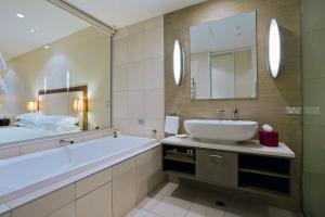 皇后镇里斯酒店&豪华公寓的带浴缸、水槽和镜子的浴室