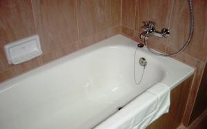 曼谷曼谷城市套房酒店的带淋浴的浴室配有白色浴缸。