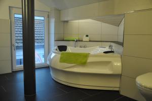 Lichtensteig目的地汽车旅馆的带浴缸、卫生间和盥洗盆的浴室