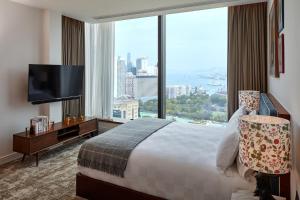 香港Little Tai Hang 酒店及服务式公寓的酒店客房设有一张床和一个大窗户