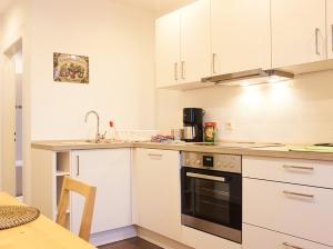 斯图加特Apartments Ho30的厨房配有白色橱柜和黑烤箱。
