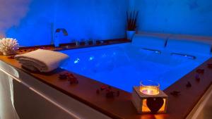 萨莱诺B&B Blu Infinito的浴室配有带蜡烛和蓝色灯光的浴缸。