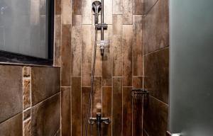 高雄美丽道商旅的浴室设有棕色瓷砖墙和淋浴。