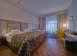 柏林Classik Hotel Alexander Plaza的酒店客房设有一张大床和一张书桌。