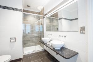 纽基赫兰酒店和Spa的一间带两个盥洗盆和淋浴的浴室