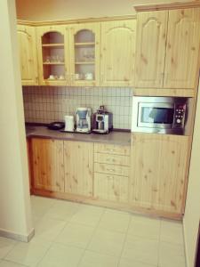 NagypáliFőnix Apartmanház的一间带木制橱柜和微波炉的厨房