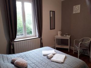 蒙特索克莱瑟通La Nouvelle Diligence的一间卧室配有带毛巾的床和窗户。