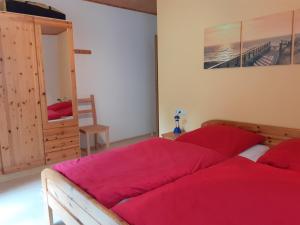 GrossbreitenbachFerienhaus Bad Hundertpfund的一间卧室配有一张带红色床单的大床