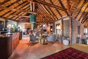 塞斯瑞姆Hoodia Desert Lodge的大房间设有木制天花板、椅子和桌子