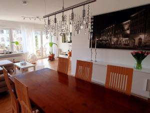 奥芬堡Haus 15的一间带木桌和吊灯的用餐室