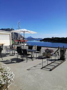 SennesvikKaikanten Kro og Rorbu的一个带桌椅的庭院和水上船只