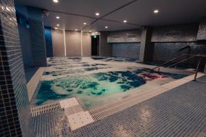 百乐费利克斯Hotel Aventus的一座带雪盖地板的建筑中的按摩浴缸