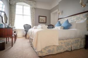 康廷考尔别墅酒店的一间卧室配有一张带蓝白色枕头的大床