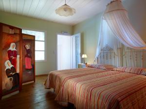 阿卡尼斯卡塔拉加里乡村套房酒店的一间卧室配有一张带条纹床罩的床和窗户