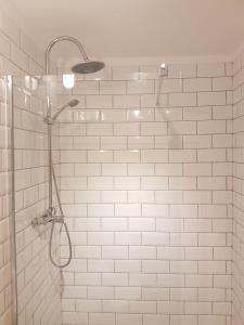 辛特拉Sintra Chalet的浴室内铺有白色瓷砖并配有淋浴头的淋浴间