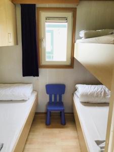 米茨兰Chalet Kocky的配有两张双层床的客房内的一张蓝色椅子