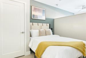 纳什维尔Sonder Belcourt的卧室配有一张白色大床和黄色毯子