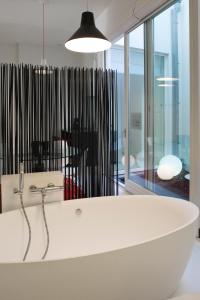 奥斯坦德利奥波德5豪华设计公寓的带窗户的客房内的白色浴缸