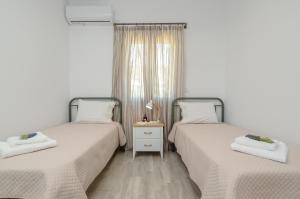 米科利维亚Orkos Naxian Wave 2的带窗户的客房内设有两张单人床。