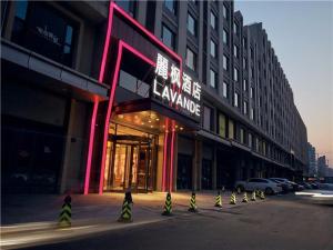 济南麗枫酒店·济南高新万达会展中心店的街道边有 ⁇ 虹灯标志的建筑物