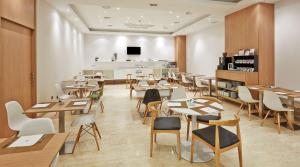 毕尔巴鄂毕尔巴鄂NH酒店的一间在房间内配有桌椅的餐厅