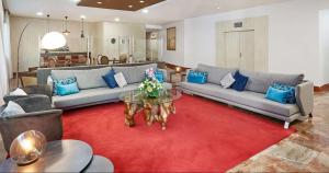 科尔多瓦科尔多瓦哈里法NH酒店的客厅配有沙发和一张红色地毯上的桌子