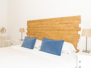 马拉加Dulces Dreams Boutique Hotel的一间卧室配有白色床和蓝色枕头